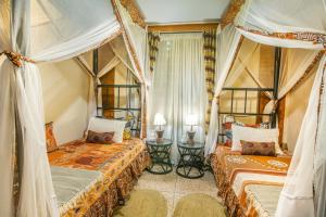 a bedroom with two beds and two curtains at JET VILLAS ENTEBBE ( JVE ) in Entebbe
