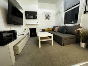 een woonkamer met een bank en een tv bij Onsite apartments in central Brentwood in Brentwood