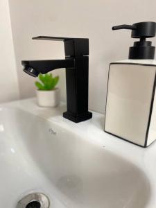 a bathroom sink with a black faucet and a mirror at Apartamento próximo a uopeccan in Umuarama