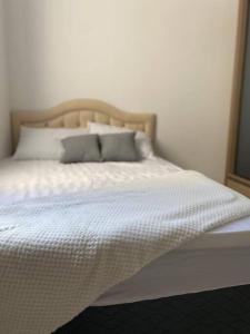Una cama con sábanas blancas y almohadas en un dormitorio en Apartamento próximo a uopeccan, en Umuarama