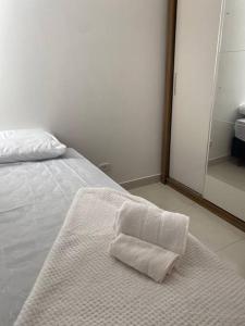 Una toalla blanca sentada en una cama en una habitación en Apartamento próximo a uopeccan en Umuarama
