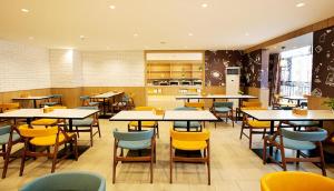 a restaurant with tables and chairs in a cafeteria at Hanting Hotel Xinyang Railway Station in Xinyang