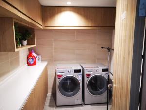 a laundry room with a washer and dryer at Hanting Hotel Xinyang Railway Station in Xinyang