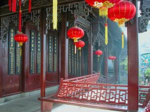 Hi Inn Hangzhou Sijiqing Qiutao North Road في هانغتشو: مقعد أمام مبنى به فوانيس حمراء