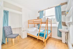 a bedroom with a bunk bed and a chair at The Old Chapel in Camborne