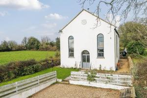 an old white church with a field behind it at The Old Chapel in Camborne