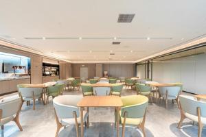 a waiting room with tables and chairs in a restaurant at Ji Hotel Nanping Jianyang District Government in Tancheng