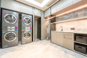 a laundry room with three washing machines and a sink at Ji Hotel Nanping Jianyang District Government in Tancheng