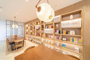 a library with a table and bookshelves at Hanting Hotel Xiamen University in Xiamen