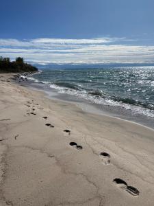 a pair of footprints in the sand on a beach at AiDaMaX #1 in Cholpon-Ata