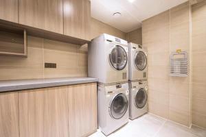 a laundry room with two washer and dryer at Hanting Hotel Zhengzhou Xinzheng Golden Avenue Logistics Park in Guodian