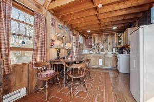 een keuken met een tafel en stoelen en een koelkast bij Tranquil Rocky Top Cabin with Mountain Views! cabin in Slanesville