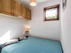a bedroom with a blue bed and a window at Appartement La Clusaz, 2 pièces, 4 personnes - FR-1-304-181 in La Clusaz