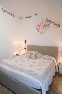 um quarto com uma cama com flores na parede em Albergo alla spiaggia em Farra dʼAlpago