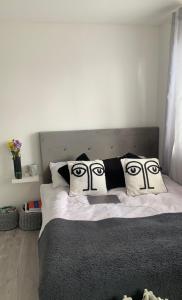 a bed with two drawn faces on the pillows at 2 Bed Home in Luton