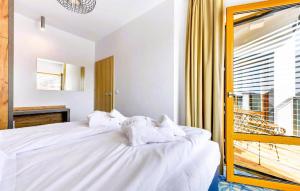 赫爾的住宿－Nice Apartment In Hel With Wifi，一间卧室配有一张带白色床单的床和一扇窗户。