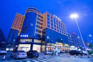 un grande edificio con auto parcheggiate in un parcheggio di Ji Hotel Guangzhou Baiyun Airport a Huadu