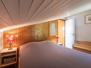 ラ・クリュサにあるAppartement La Clusaz, 6 pièces, 7 personnes - FR-1-304-175の木製の壁のベッドルーム1室(大型ベッド1台付)