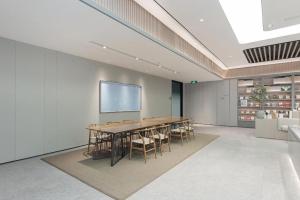 a conference room with a table and chairs and a screen at Ji Hotel Wuhan Jiedaokou in Han-yang-hsien