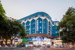 um edifício azul com carros estacionados em frente em Hanting Hotel Xiamen Huli Avenue Free Trade Zone em Huli