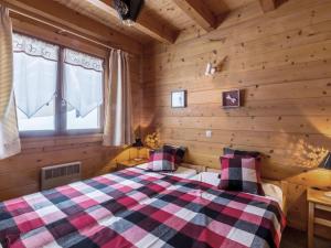 a bedroom with a bed in a log cabin at Chalet La Clusaz, 6 pièces, 10 personnes - FR-1-304-164 in La Clusaz