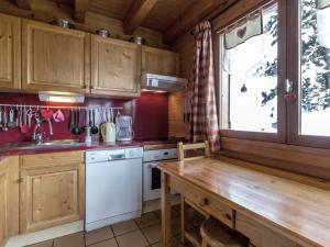 a kitchen with wooden cabinets and a wooden table at Chalet La Clusaz, 6 pièces, 10 personnes - FR-1-304-164 in La Clusaz