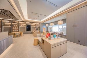 a large room with a store with tables and chairs at Ji Hotel Xuzhou Administrative Center Metro Station in Liuji