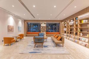 a living room with a couch and chairs and shelves at Hanting Hotel Yangzhou Jiangdu Wenchang East Road in Jiangdu