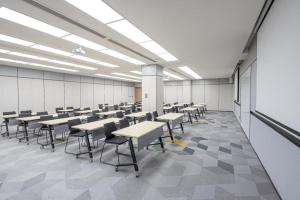 a classroom with desks and chairs in a room at Hanting Hotel Yangzhou Jiangdu Wenchang East Road in Jiangdu