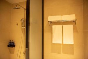 bagno con doccia e asciugamani appesi a una parete di Hanting Hotel Ordos Yijinholoqi Wenming Road a Ordos