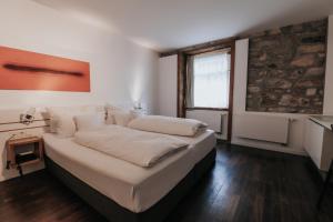 a bedroom with a large bed with white sheets at Design Hotel & Restaurant Löwen in Ulm