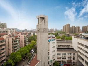 a tall clock tower in a city with buildings at Hanting Hotel Hangzhou Zhejiang University City College in Hangzhou