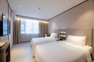 Cama ou camas em um quarto em Hanting Hotel Wuhan Qingshan Zhongyuan Plaza