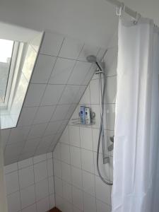 ein Bad mit Dusche und Duschvorhang in der Unterkunft Charmante Wohnung im Hinterhof in Neukirchen-Vluyn