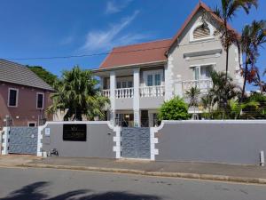 uma cerca branca em frente a uma casa em Luxe Florida Grand Hotel em Durban