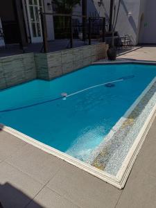 a swimming pool with blue water in front of a house at Luxe Florida Grand Hotel in Durban