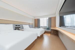 a hotel room with two beds and a large window at Ji Hotel Wuhan Yellow Crane Tower Shouyi Road in Han-yang-hsien