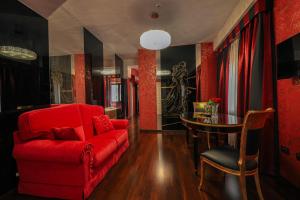 a living room with a red couch and a table at Hotel Mastrodattia in Celano
