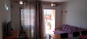 ein Wohnzimmer mit einem lila Sofa und einem Fenster in der Unterkunft Edyro Yumbo apartment in Playa del Ingles