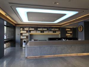 eine Lobby mit einer Rezeption und einer Uhr in der Unterkunft Ji Hotel Bayanzhuo'Er Books Tower in Bayan Nur