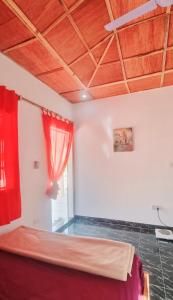 um quarto com uma cama e uma cortina vermelha em KAIRO em Brufut