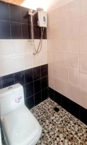 uma casa de banho com WC e um telefone na parede em KAIRO em Brufut