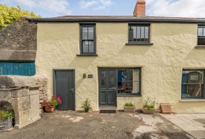 a house with a blue door and windows at Stable Cottage in Pembroke