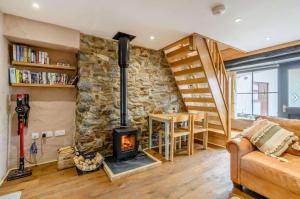 a living room with a stone wall and a wood stove at Stable Cottage in Pembroke