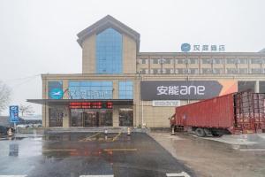 un grande edificio con un camion davanti di Hanting Hotel Jiaozuo Wuzhi Yingbin Avenue a Wuzhi