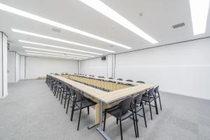 una sala conferenze con un lungo tavolo e sedie di Hanting Hotel Jiaozuo Wuzhi Yingbin Avenue a Wuzhi
