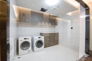 a laundry room with two washers and a washing machine at Hanting Hotel Shanghai Qingpu Huijin Road Metro Station in Qingpu