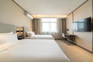 Hanting Hotel Shanghai Safari Park Nanzhu Road tesisinde bir odada yatak veya yataklar