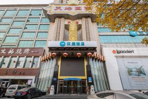 een groot gebouw met een draak aan de voorkant bij Hanting Hotel Jinan Beiyuan Street Ouyada in Licheng