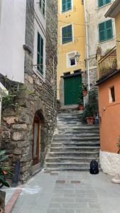un conjunto de escaleras que conducen a un edificio con una puerta verde en Carattino, en Vernazza